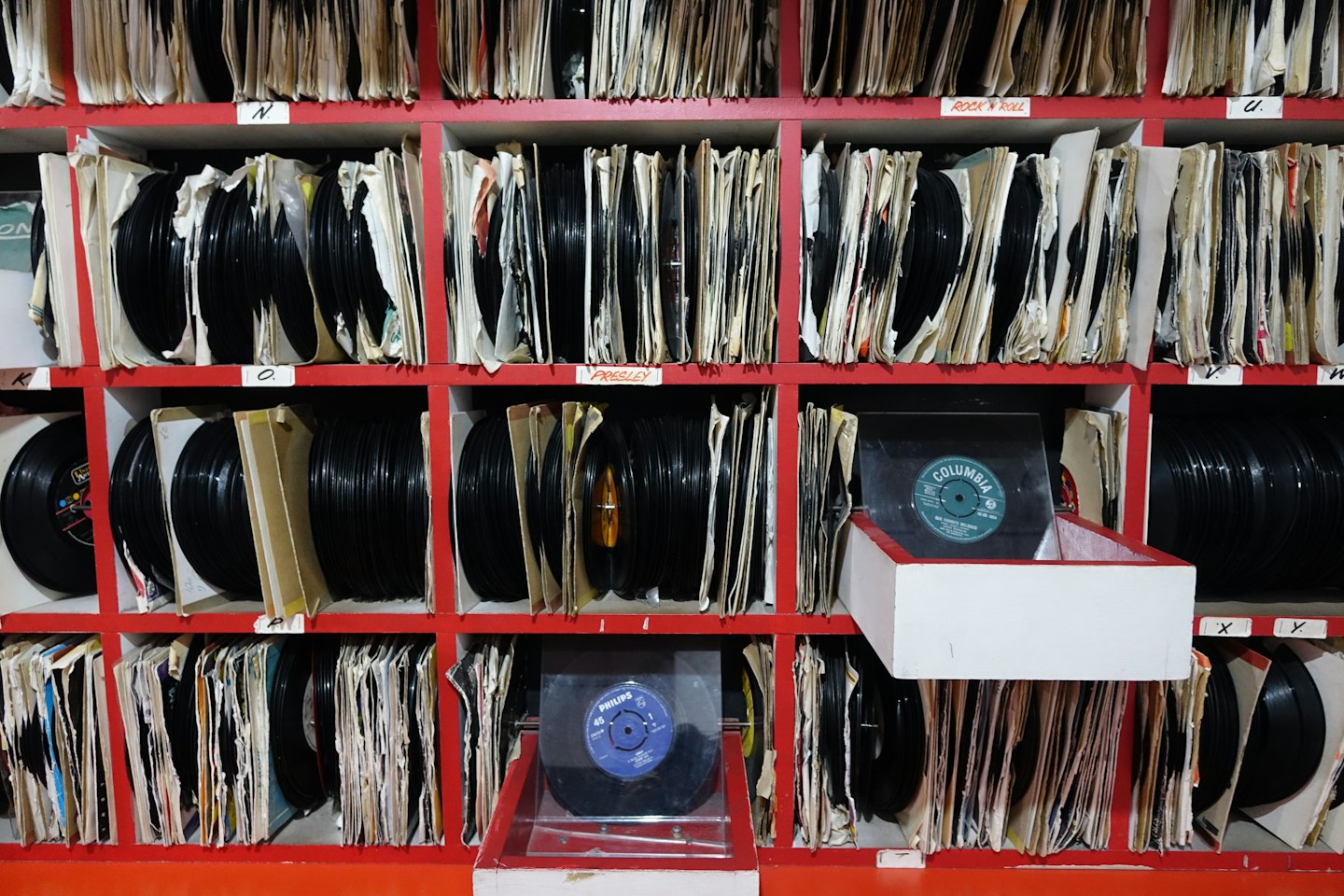 Schallplatten in einem roten Holzregal.