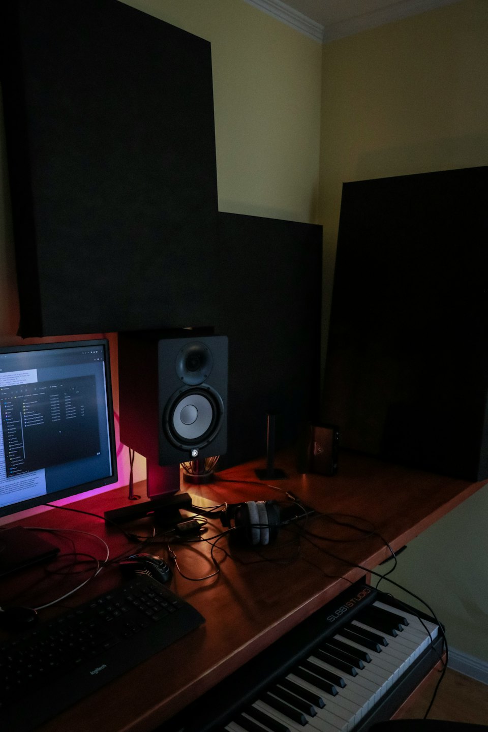 Heim-Musikstudio-Arbeitsplatz mit Tastatur und Monitor.